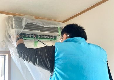 講師が受講生に浴槽の蛇口清掃を指導している様子
